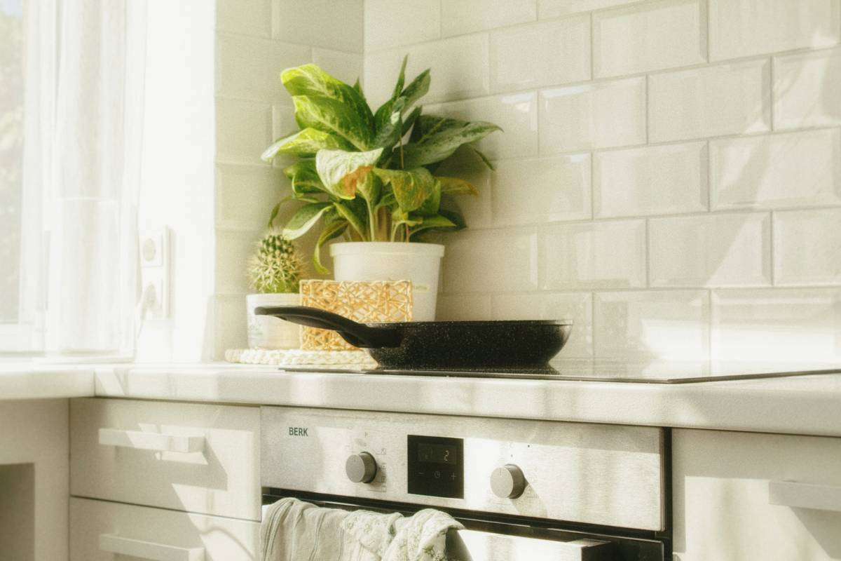 coffee mugs stainless insulated on a wooden countertop next to coffee beans and a reusable tote bag